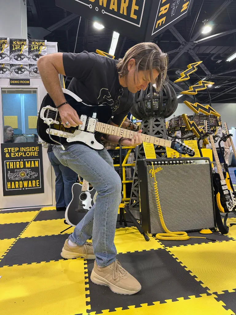 Michael playing guitar at NAMM